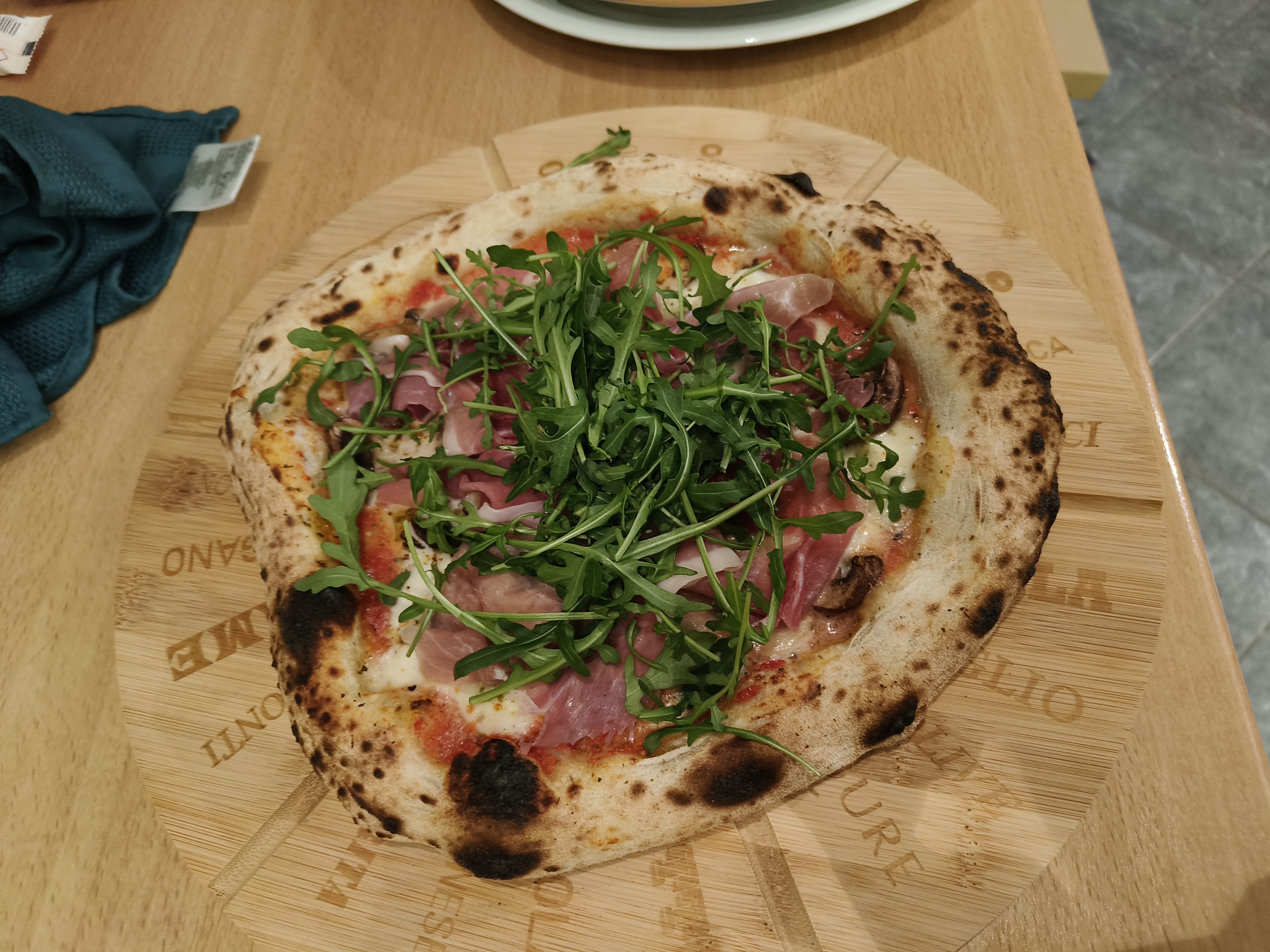 Pizza met parmaham, champignons en rucola
